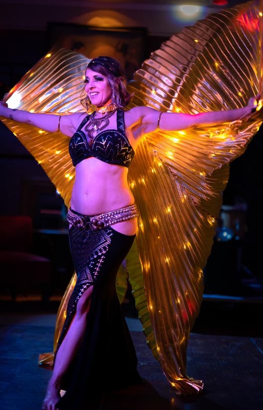 Jessica Cooper performing with golden isis wings
